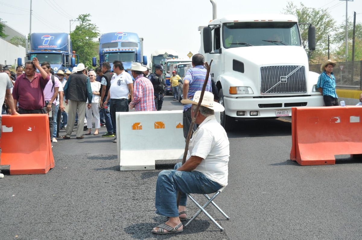 Bloquean la autopista; demandan el retiro de tres casetas de peaje