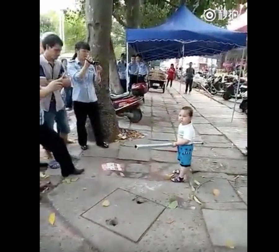 Niño chino toma un tubo de metal para defender a su abuelita de policías