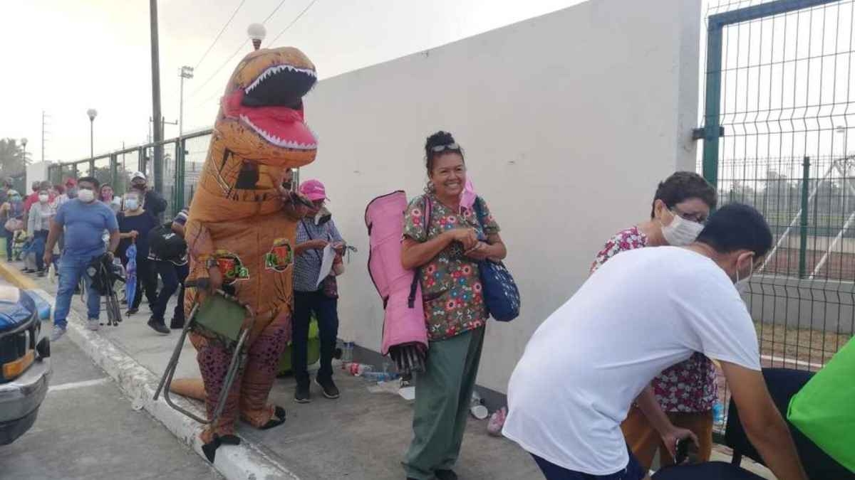 “Dinosaurio” acompaña a su mamá a vacunarse contra COVID-19