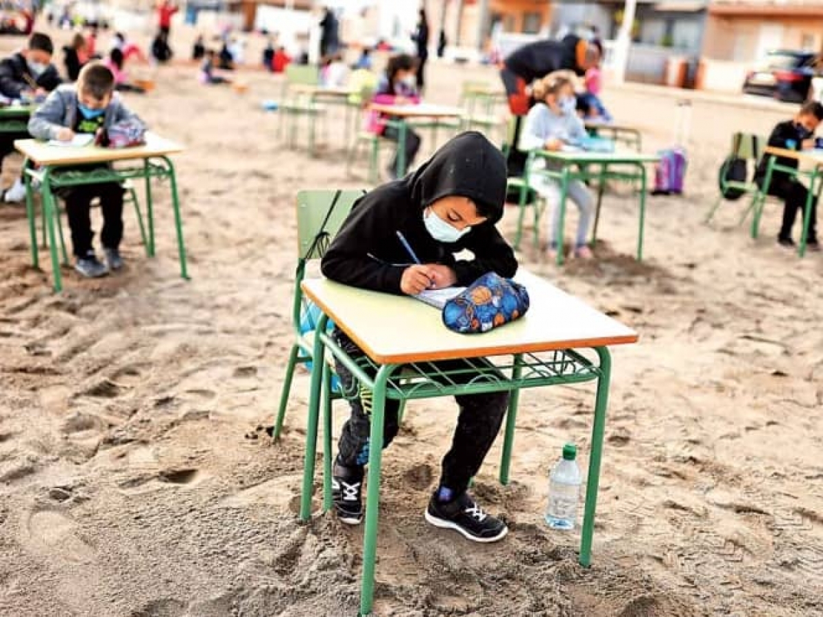 Niños toman clases a la orilla del mar en España
