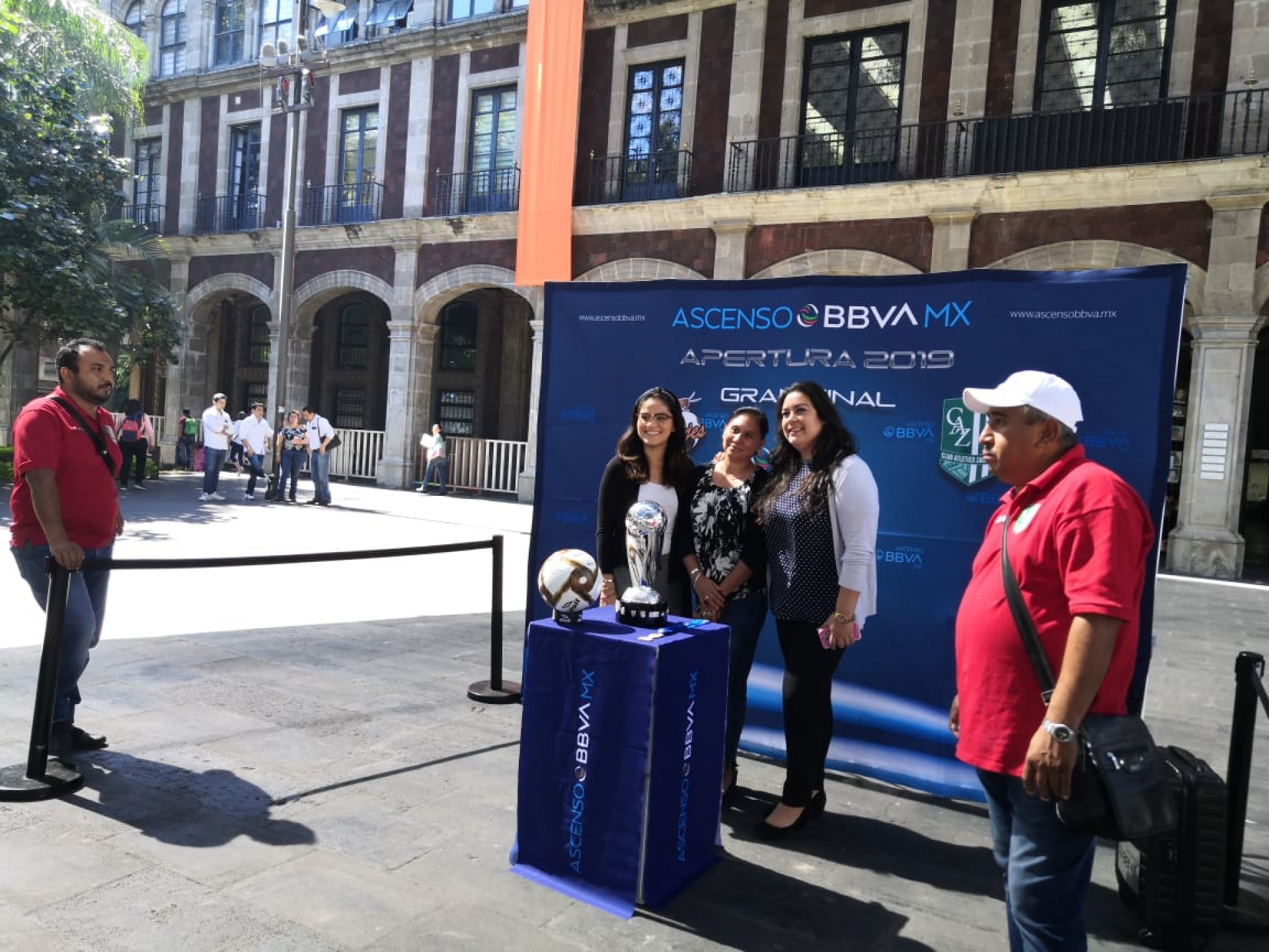 Aficionados al futbol se fotografían junto a la copa de la Liga de Ascenso, en Cuernavaca