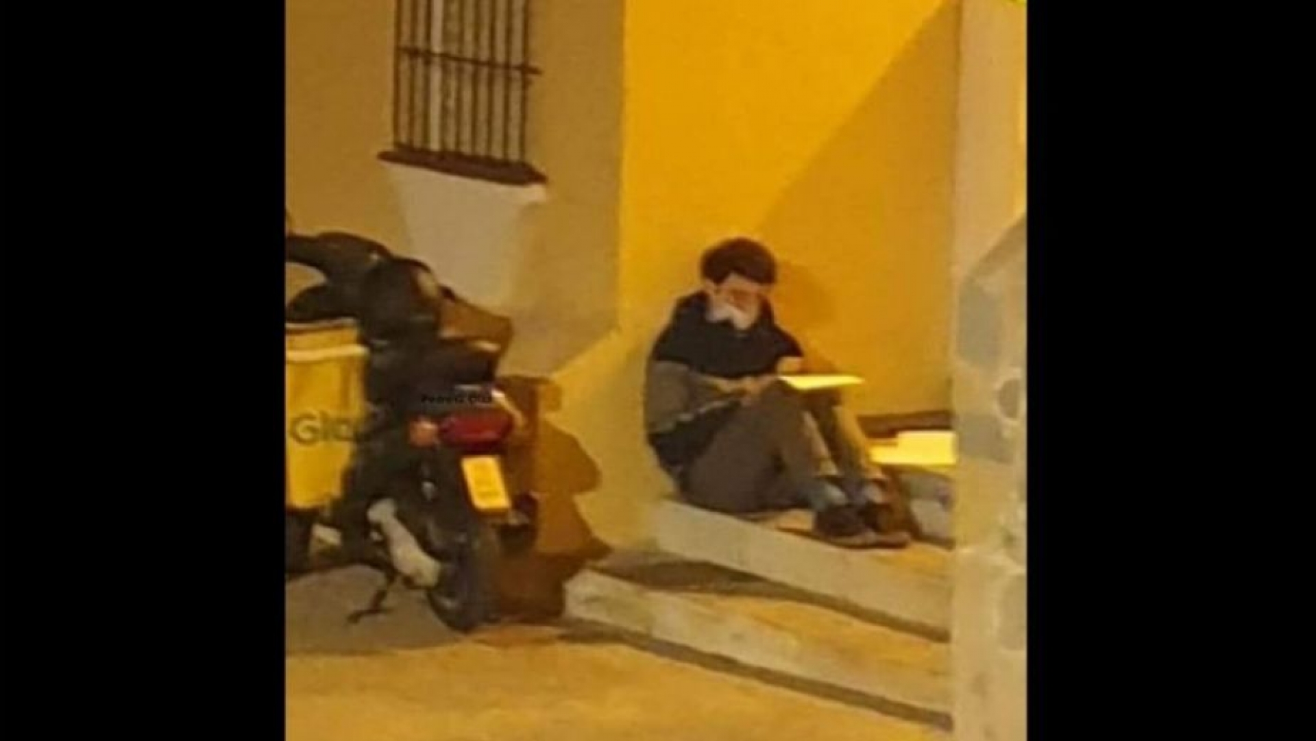 Un estudiante hace su tarea mientras trabaja como repartidor de comida