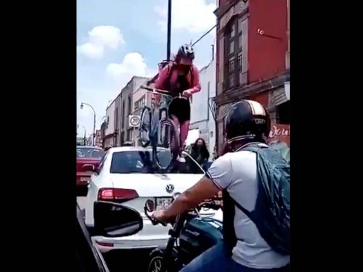 Joven pasa con todo y bici por encima de auto que no respetó la ciclovía
