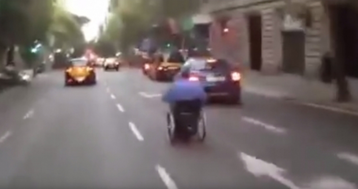 Un hombre conduce su silla de ruedas a toda velocidad por las calles de Barcelona